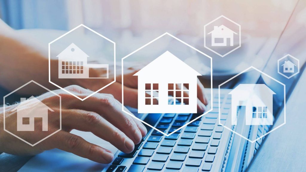 A person navigates property investing platforms online, highlighting virtual representations of homes overlaid on a laptop screen. The digital interface showcases various house icons that signify different investment properties, emphasising the modern, digital approach to real estate investment.