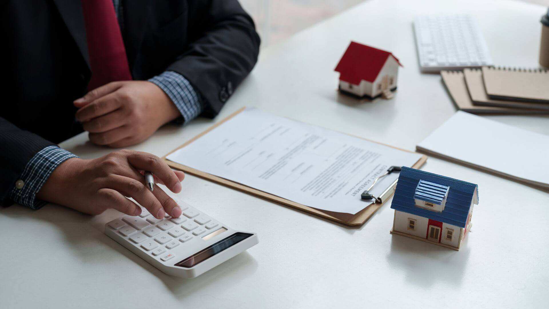 Close-up of a property investor reviewing documents, calculating expenses, and considering investment property costs