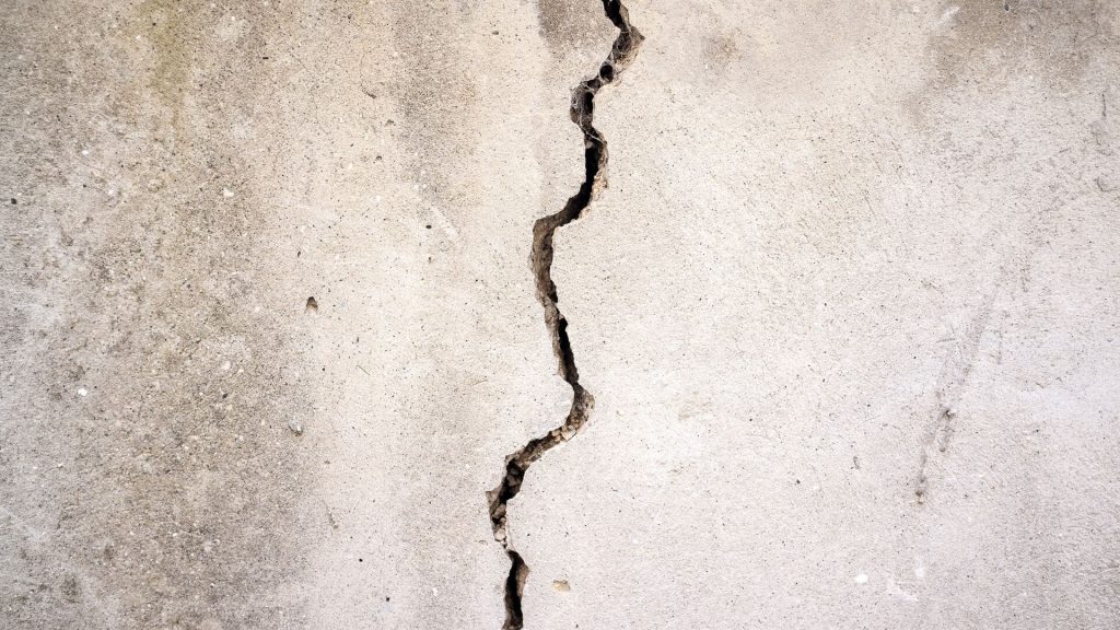 Crack in the concrete wall of an investment property, highlighting the importance of regular property inspections and maintenance.