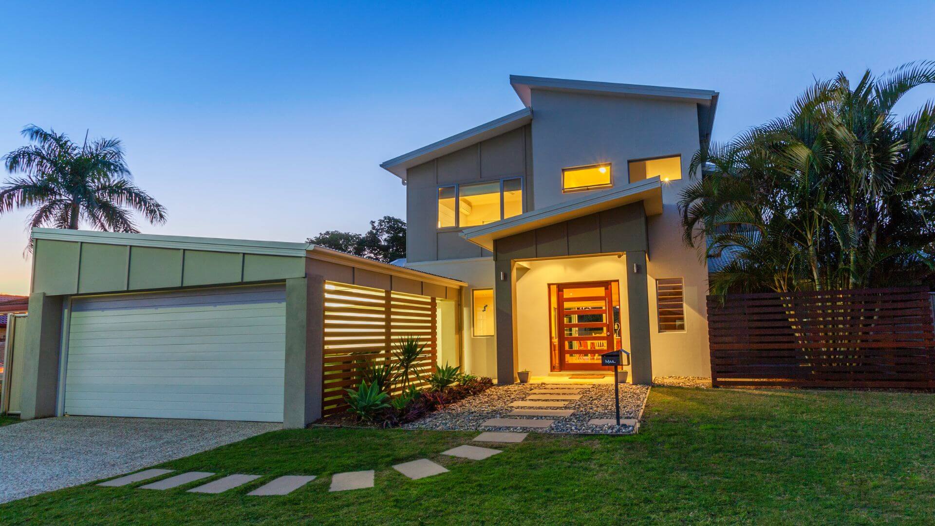 Modern home with a well-lit exterior, symbolising the advantages of selling off-market, such as privacy, exclusivity, and appealing presentation.